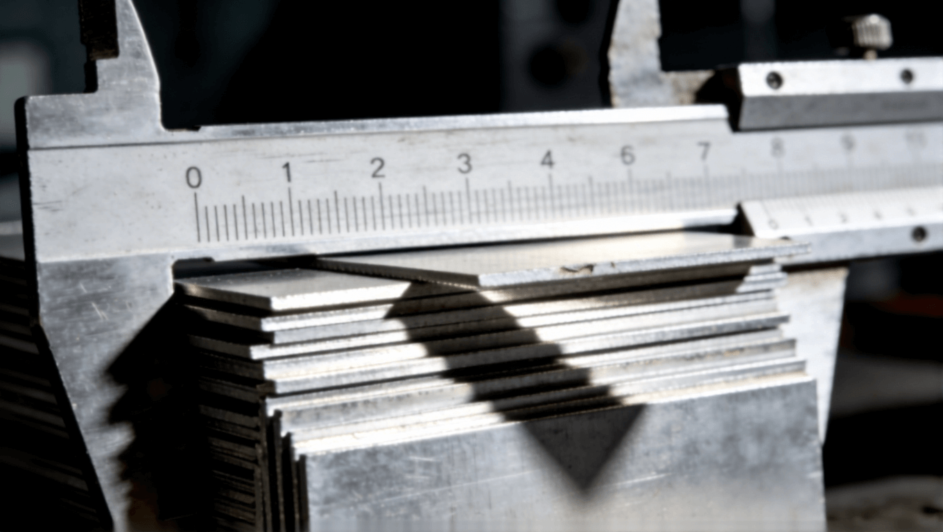 微距攝影展示鋁基板厚度公差，卡尺測量下參差交錯，側光凸顯縫隙與陰影